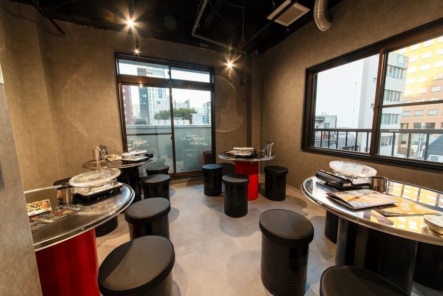 大きな窓から街並みが見渡せる開放的な空間。シンプルで無骨なスチールテーブルと丸椅子がスタイリッシュで、カジュアルな飲み会や仲間同士の集まりにぴったり。適度な距離感と落ち着いた照明で、雰囲気を楽しみながらゆったり食事ができます。