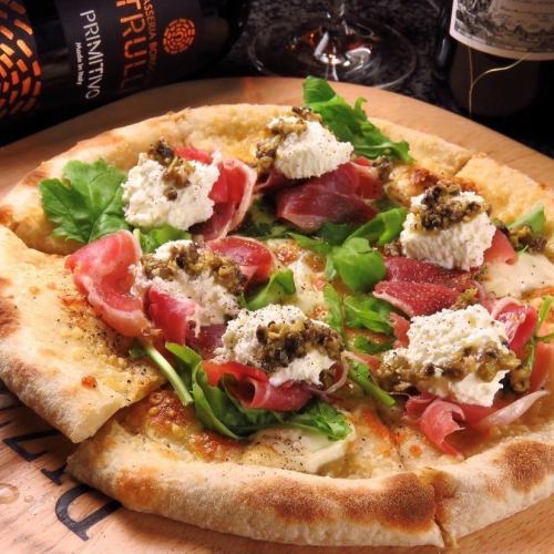 Healthy pizza with prosciutto and leaf salad, served with cream cheese