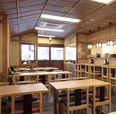 【蕎麦打ちのライブ感も楽しめる】店内の入り口にはガラス張りの調理場を設置。蕎麦打ちのライブ感を楽しみながら、打ちたての手打ち蕎麦をご堪能いただけます。夜は蕎麦を使った一品系メニューも楽しむことができ、ランチ使いだけでなく一人飲みや宴会にもぴったりです。