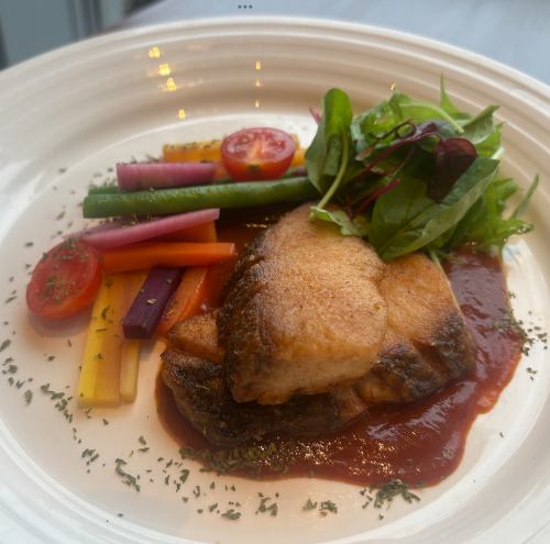 Pan-fried sea bass in tomato sauce with colorful carrots