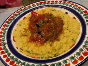 [Saffron-flavored couscous] Sicilian-style lamb stew with bell peppers, eggplant, and zucchini in a spicy tomato sauce.