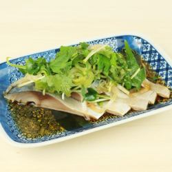 Marinated mackerel covered in condiments.