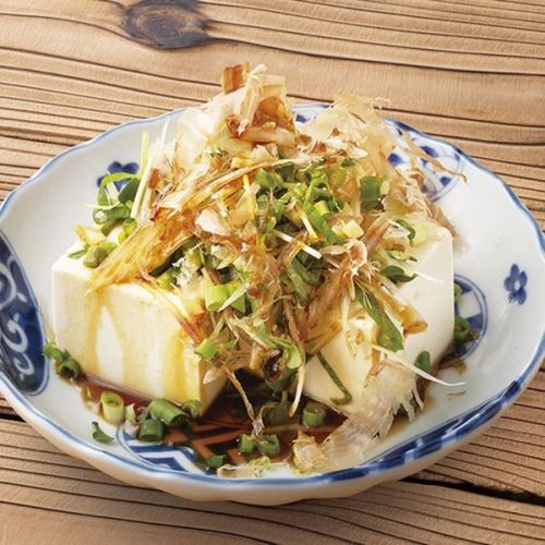 Cold tofu covered in condiments/assorted pickles