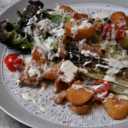 Grilled Caesar salad with chicken neck and romaine lettuce