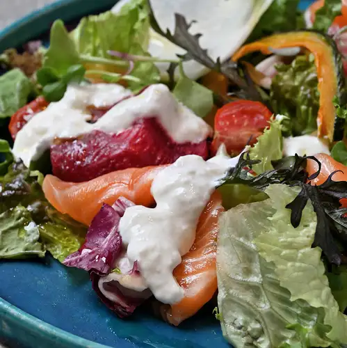 Salmon marinated in herbs and stracciatella served as a garden salad.