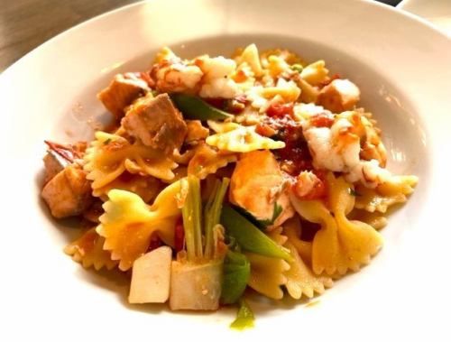 Farfalle with cherry salmon, red shrimp, and spring vegetables in fresh tomato sauce