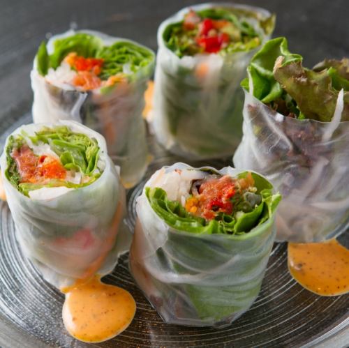 Fresh spring rolls of salmon, avocado and green vegetables with sweet chili sauce