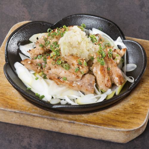 Grilled chicken neck with green onion and salt on an iron plate