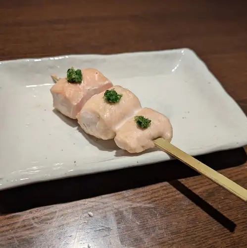 Chicken breast skewers grilled over straw