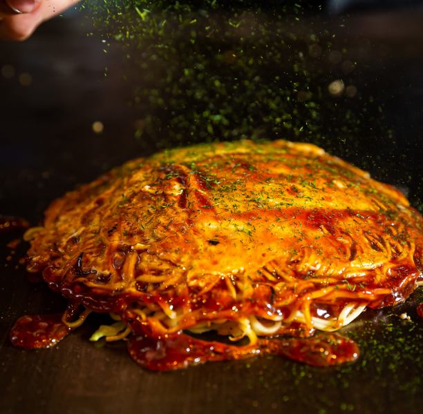 [Okonomiyaki] Served hot on an iron plate! The popular dish is topped with plenty of green onions and squid tempura.