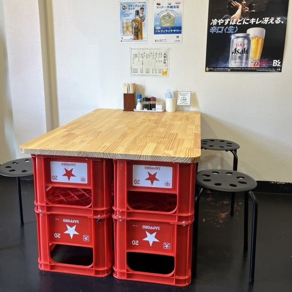 【4名掛けテーブル席】店内に1卓だけのユニークな特等席。ビールケースをベースにしたテーブルが印象的で、どこか屋台のような温かみと懐かしさを感じさせます。気取らず過ごせる雰囲気は、仲間との語らいやちょい飲みにぴったり。ラフで居心地の良い一席で、自然と会話も弾みます。　