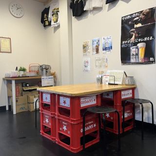店内にひとつだけの4名掛けテーブル席。ビールケースをベースにしたテーブルは、素朴で親しみやすい雰囲気が魅力。まるで昔懐かしい縁側のような温もりがあり、友人同士のちょい飲みやご家族との食事にぴったりです。