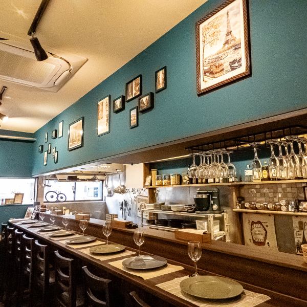 深いグリーンの壁に旅の風景を切り取ったアートを配置。照明を抑えた落ち着いた店内で、料理と向き合いながらゆったりと時間を過ごせます。