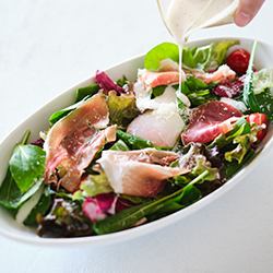 Caesar salad with raw ham and soft-boiled egg