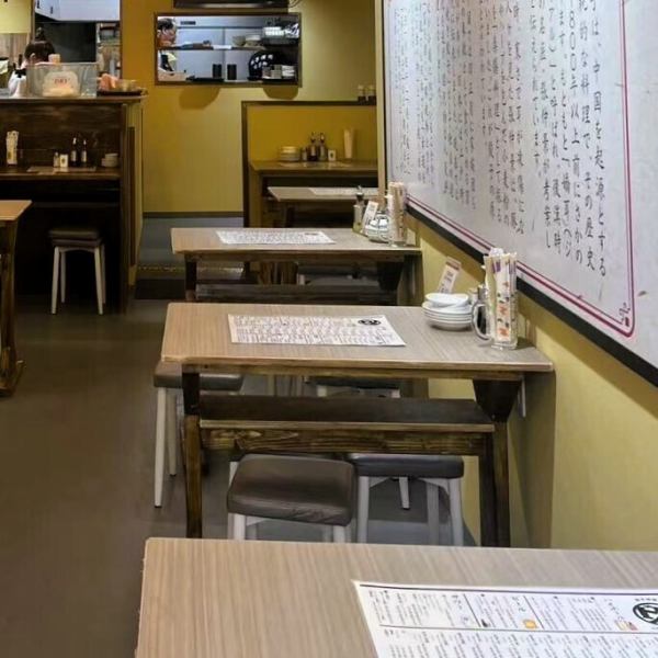 店内の中心にはテーブル席がゆったりと配置され、グループでの食事や中規模な宴会にぴったりの空間を提供します。木の質感とオレンジの柔らかな照明が心地よく、リラックスしながら会話を楽しめる雰囲気。テーブル同士の間隔も広めに取られているため、周囲を気にせずプライベートな時間を過ごせるのも嬉しいポイントです。