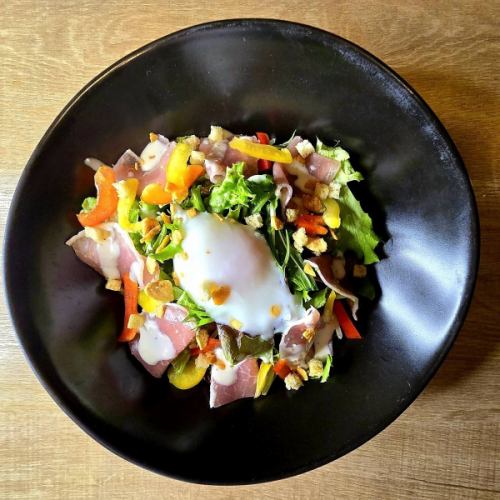 Prosciutto Caesar salad topped with soft-boiled egg