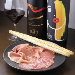Three kinds of chestnut-fed pork prosciutto (Serrano, Lomo, and Salsiccia) served with grissini.