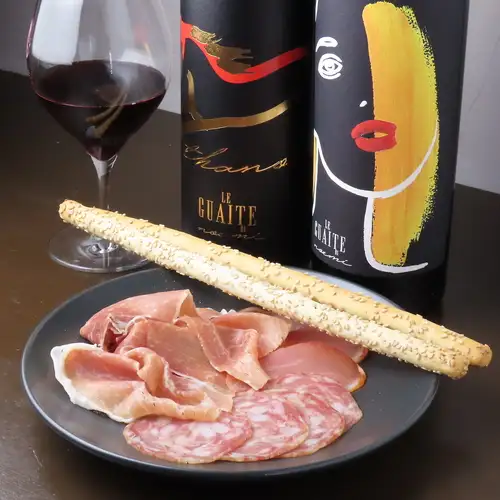 Three kinds of chestnut-fed pork prosciutto (Serrano, Lomo, and Salsiccia) served with grissini.