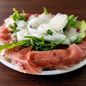 Protruding prosciutto and arugula pizza