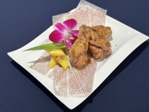 Deep fried chicken wings with Cajun spices and roasted pineapple