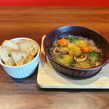 Seafood and vegetable ajillo served with baguette