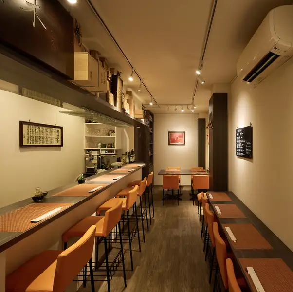 温かみのある照明が心地よく木の質感が生きる落ち着いた店内が印象的な、門前仲町「割烹佐々木 はなれ」。カウンター席では料理人の手仕事を眺めながら一品一品をじっくり味わえ、奥のテーブル席ではゆったりとした食事の時間を楽しめます。上質で落ち着いた空間が、旬の食材を生かした和食の魅力をより一層引き立てます。