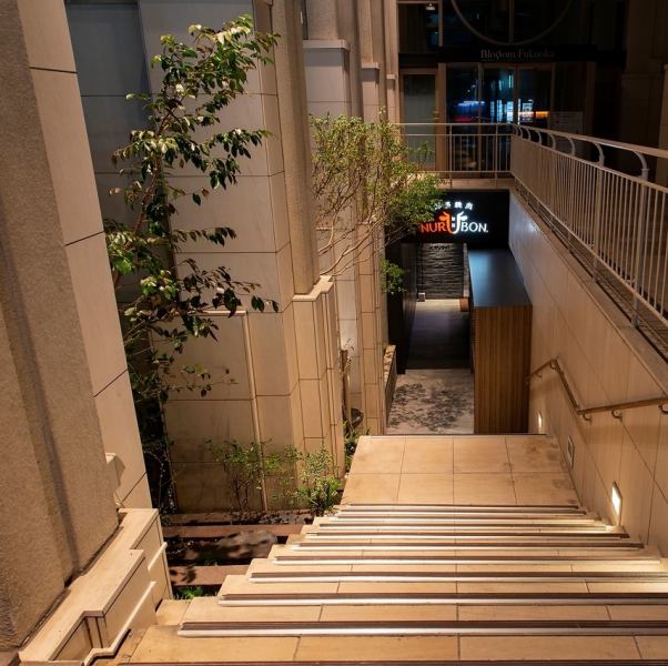 JR九州ホテルブラッサム福岡の地下1階。階段を下りる途中には、植栽があり、わくわく感・期待感が高まる入口です。階段を下りてすぐ右手には、牛をモチーフにしたモニュメントがあります。