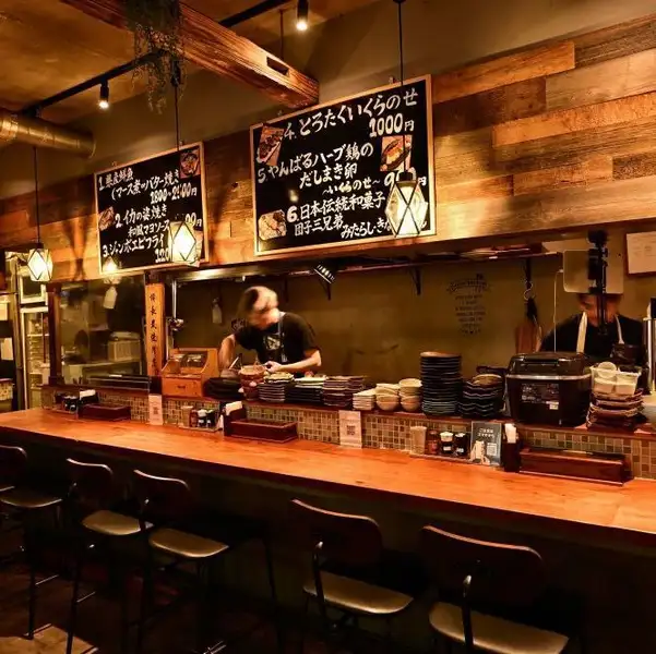 お一人様やデートに最適なカウンター席は、店内の活気を間近に感じられる特等席です。温かみのある木製カウンターと、モダンなコンクリートの壁面が調和したお洒落な空間が広がります。目の前の焼き台から立ち昇る香ばしい香りを楽しみながら、職人技が光る炭火串焼きを心ゆくまでご堪能ください◎