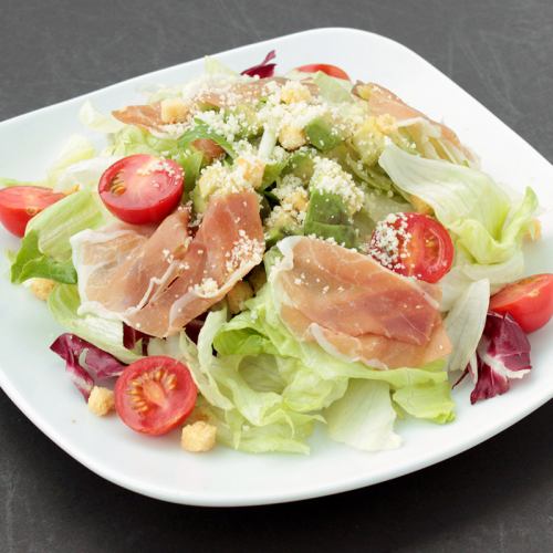 Caesar salad with raw ham and salmon