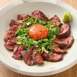 Beef skirt steak grilled over straw, topped with egg yolk