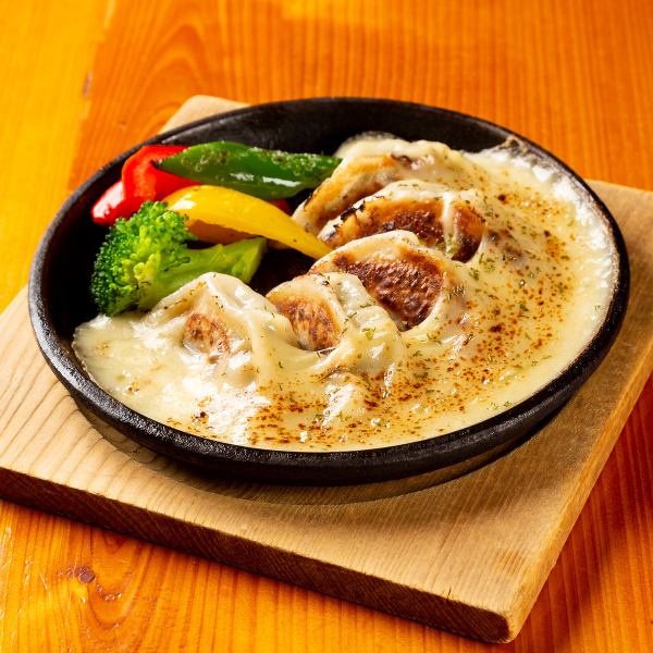 Cheese fondue sauce with dumplings and colorful vegetables