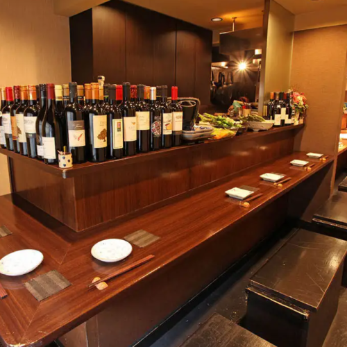 <p>落ち着いた和モダンの店内。14名様が座れるカウンター席をご用意しました。カウンター上には、本日のおばんざいやワインのボトルが並び、お好きな料理やワインを目で見ながら選ぶことができます。座席はベンチシートなので、お一人様やカップルなど、1名様～2名様でのご利用に最適なお席です♪</p>