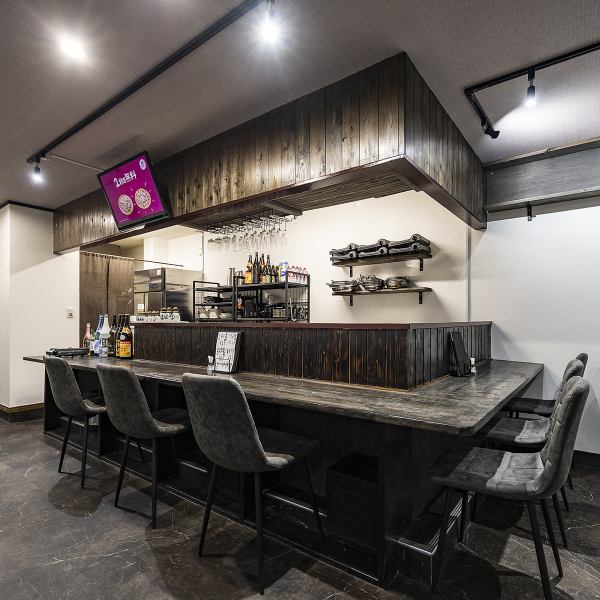 【カウンター】木の温かさが心地よいL字カウンターは、料理が仕上がる音や香りが伝わる特等席。1～3名で使いやすく、さく飲みにも晩ごはん利用にもぴったり。ボトル棚やグラスの配置も雰囲気づくりにこだわり、自然と会話が弾む落ち着いた大人のカウンター空間です。