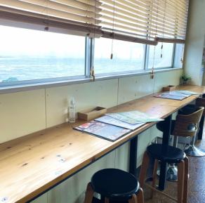 Counter seats by the window facing the sea.