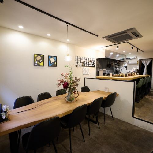 <p>美しい曲線を描く大きな一枚板の8名掛けテーブル席がございます。壁にはモダンなアートが飾られ、落ち着いた大人の隠れ家のような雰囲気。ご家族での夕食や、少人数のグループ利用に最適です。窓際に並ぶボトルがお洒落な空間を演出し、日常を少し特別に変えてくれる、そんな素敵なひとときを約束します。</p>