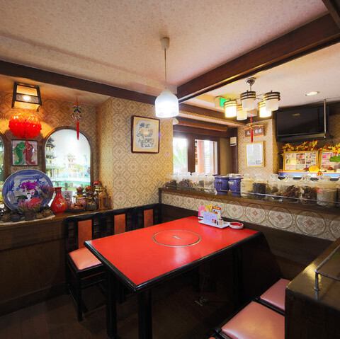 <p>広々としたテーブル席は、少人数から中規模のグループまで柔軟に対応可能です。隣の席との間隔もしっかり確保されているため、周囲を気にせずお食事に集中できる環境。鮮やかな赤を基調とした店内は居心地も良く、都会の喧騒を忘れてリラックスできる空間作りを徹底。ご家族や友人との楽しい談笑に華を添えます。</p>