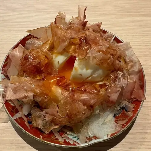 Soft-boiled egg with plenty of bonito flakes and potato salad