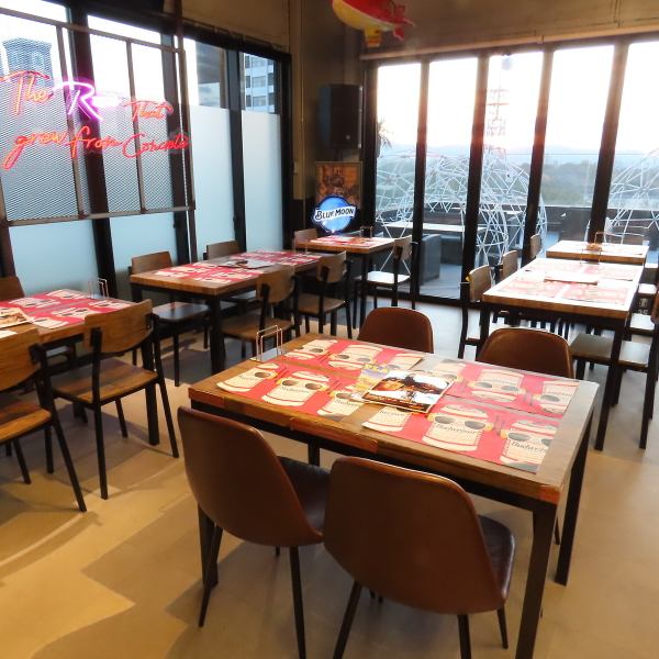 【四角木のテーブル席】店内にあるスタンダードなテーブル席で、4名様×4卓、2名様×2卓をご用意。1名様～最大20名様まで幅広くお使いいただけます。お洒落で開放感のある店内からは、ルーフトップならではの外の景色も一望でき、14台のモニターも完備しているので、ご要望に応じて映像での演出にも対応可能です。