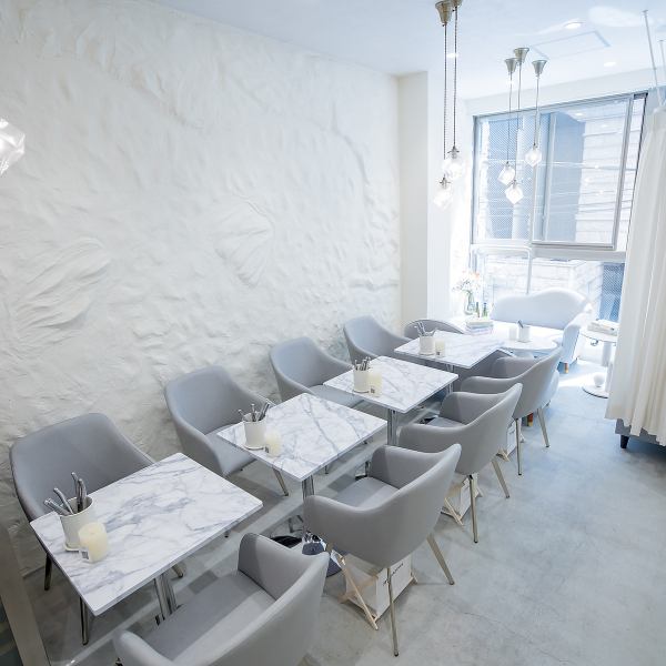 ≪壁際のテーブル席≫ 大理石のテーブルが特徴的なこの空間は、スタイリッシュで洗練された雰囲気を醸し出しています。滑らかな表面は、食事をより一層引き立て、友人との会話も弾むこと間違いなし。テーブルごとに心地よい間隔が保たれており、リラックスした時間を過ごすのに最適です。お気軽にご利用ください！