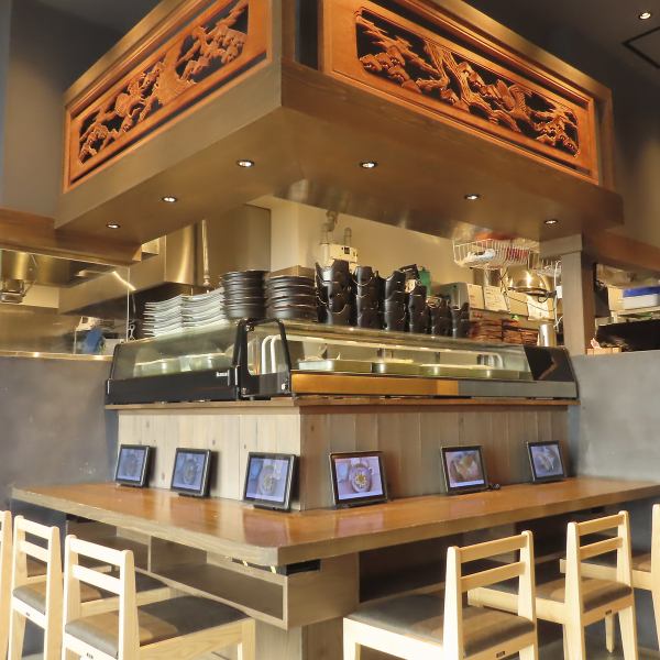 【カウンター席】サク飲み大歓迎！テーブル席と同様に、木を基調としたカウンターの席が並んでいます。昼だけなく夜も定食メニューのご提供を行っておりますので、仕事終わりやふらっと一杯飲みたいときもお気軽にお立ち寄りいただけます。おひとり様でもご利用いただきやすいお席です。