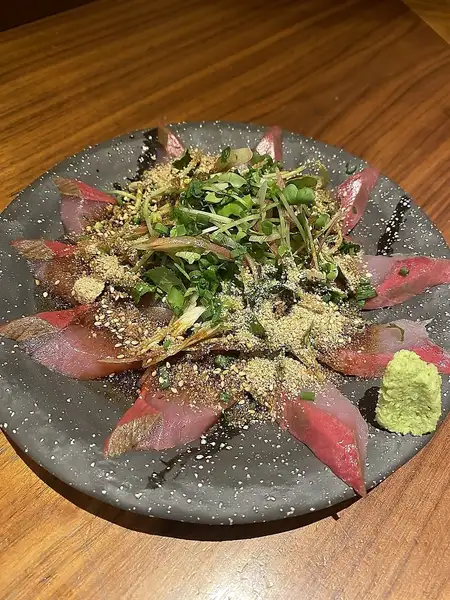 【名物ゴマぶり】新鮮なブリに薬味とゴマ，特製のタレをかけた必食の逸品！
