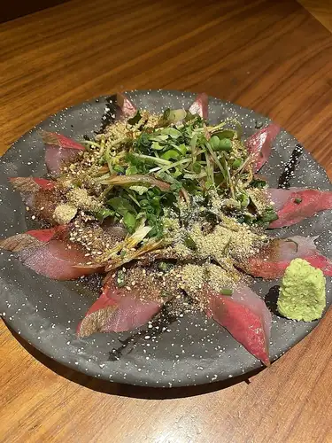 【名物ゴマぶり】新鮮なブリに薬味とゴマ，特製のタレをかけた必食の逸品！