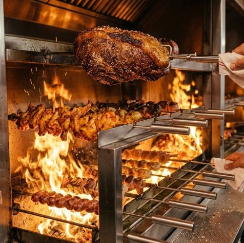 本格炭火で焼き上げたシュラスコを目の前でカット。自家製ソースや岩塩など多彩な味わいで楽しめる肉バル◎