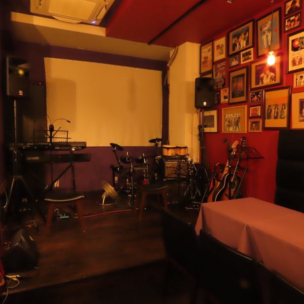 落ち着いた雰囲気が漂う店内には、ミニステージや数百枚のレコードが並び、音楽好きにはたまらない空間が広がります。白黒のダイヤ模様が印象的な丸テーブルが配置され、遊び心のあるインテリアも魅力。まるで隠れ家のように見つけにくい立地も、特別感を演出しています。