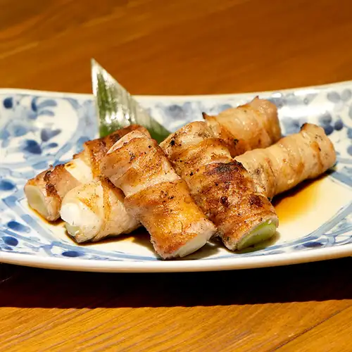 Pork belly wrapped around a whole green onion