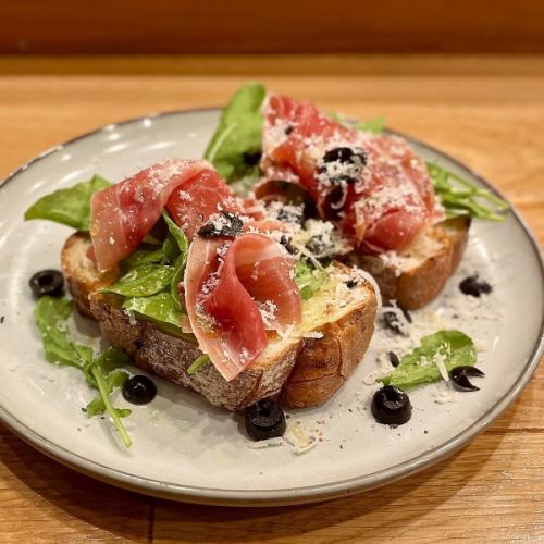 Pizza toast with prosciutto and arugula