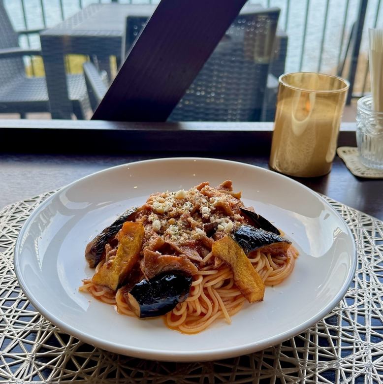 Pasta with seasonal vegetables and bacon in tomato sauce