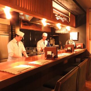 目の前で調理風景を見ながらお食事をどうぞ。ゆったりとした時間を過ごして頂けるカウンター席も人気のお席です。席の頭上の欄間も輝きます。お一人さまからでもお気軽に。