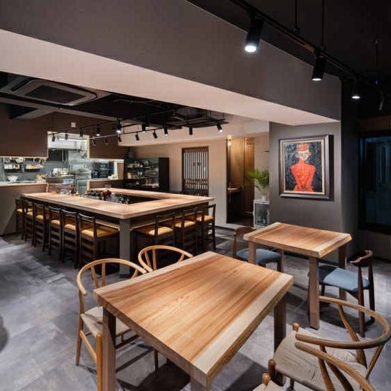 カウンターに使った大杉から切り出した3席用と4席用のテーブル席、繋げて7席にも使える。このほかに、通常の木製テーブル2席用が4テーブルある。これも繋げると8席にもなる。テーブル席は合計15席になる。席の構成により、上のライトを自由に調整している。テーブル席はこのほか個室6席もある。