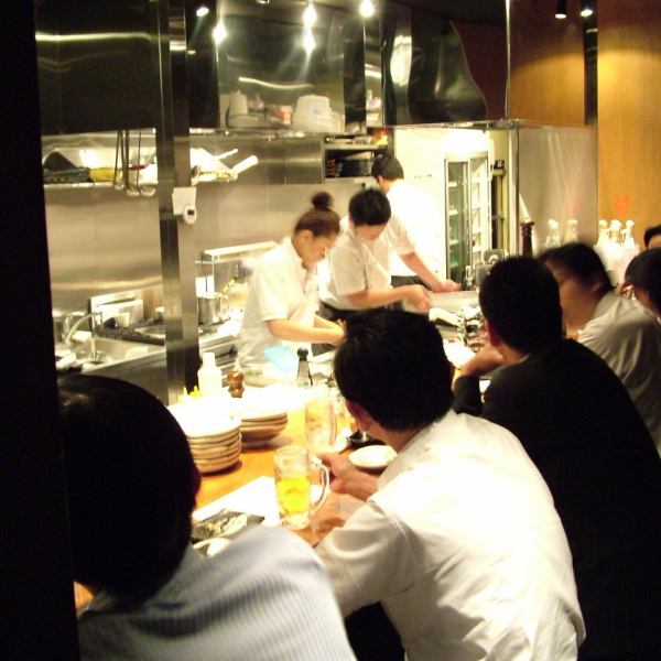 座ってみて実感できる広々としたカウンターです。アパの樹で造ったカウンターは店内に風情を与え、美味しいお酒と臨場感を味わえる特等席です。 目の前で作られていく料理に期待が膨らんでいきます。調理風景を目で楽しみ、当店のこだわり料理の数々を口で味わって、素敵なひと時をお過ごしください。